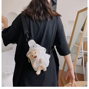 Dettaglio borsa a tracolla in tela bianca con orsetto di peluche 3D e tracolla regolabile