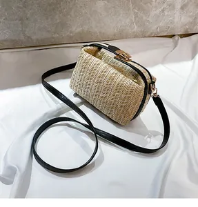 Detail of hand-woven straw crossbody bag featuring premium black leather trim and gold clasp