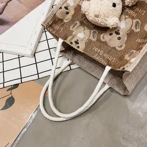 Close-up of jute tote bag featuring cute cartoon bear print and soft cotton rope handle