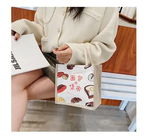 Detailed close-up of a Japanese canvas tote bag with bread illustration and soft rope handle