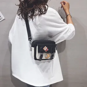Cute black and white canvas crossbody bag with bear embroidery worn by a model