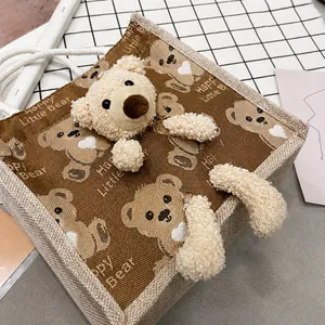 Detail of canvas lunch bag featuring 3D plush bear and Happy Little Bear printed pattern