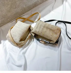 Top view of woven straw bags with camel and black PU straps on a marble surface