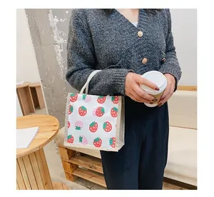 Detailed macro view of strawberry print mini canvas tote with woven hemp rope handles