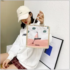 Detail of canvas handbag featuring artistic sailboat pattern and soft cotton rope handle