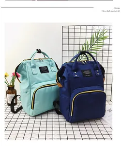 Detail view of mint green and navy blue nylon diaper bags with large opening zippers