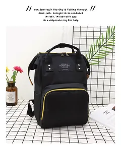 Detail of black diaper backpack with yellow zippers and Living Traveling Share patch