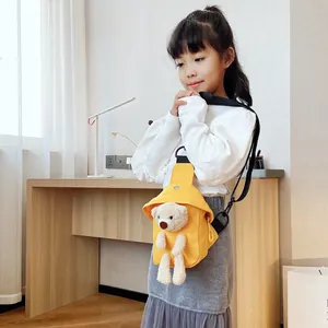 Dettaglio del borsello in tela gialla con orsetto di peluche indossato da una bimba