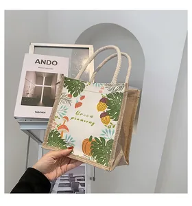Detailopname van een jute canvas draagtas met plantenprints en handvaten van henneptouw