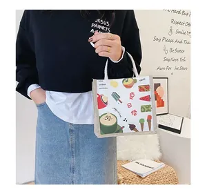 Detail of canvas tote bag with colorful summer illustrations held by a model