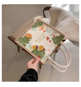 Detail van canvas draagtas met bosplantenpatroon en dik handvat van katoenen touw