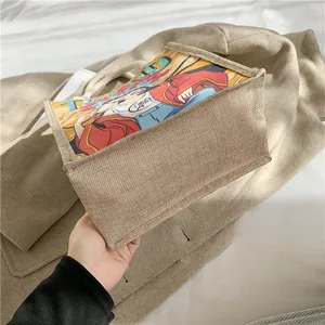 Detail of jute tote bag showing coarse rope handles and colorful anime character print