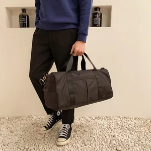 Lifestyle shot of a black nylon fitness bag with reinforced handles and waterproof texture