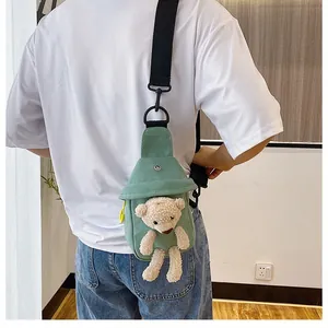 Green canvas chest bag with 3D plush bear detail and contrasting yellow zipper