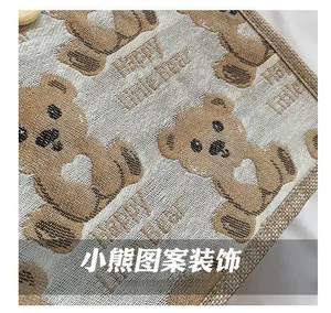 Detail of woven linen fabric with Happy Little Bear patterns and textured beige finish