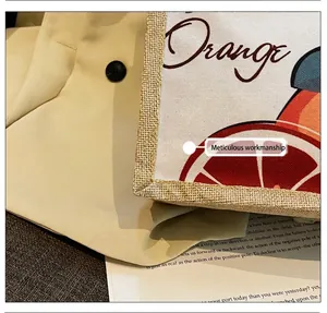 Detailopname van getextureerde canvas stof met oranje opdruk en artistieke belettering