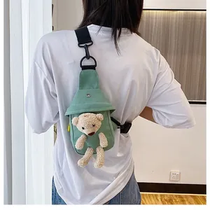 Green canvas chest bag with a 3D plush bear shown on a model for size and fit