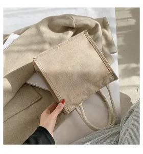 Detail van lichtbruine jute tas met rustieke touwhandvatten in minimalistische stijl
