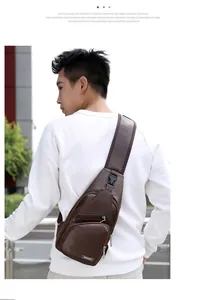 Détail d'un sac de poitrine en cuir marron avec zips multiples et large bandoulière réglable