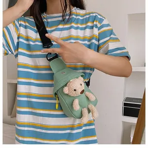 Detail of light green canvas chest bag featuring a cute 3D plush bear on striped shirt