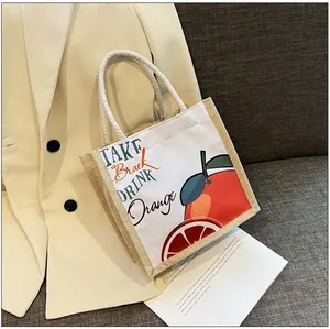Detail of jute and canvas tote bag featuring orange print and braided cotton handles