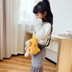 Dettaglio borsa a tracolla gialla in tela con orsetto 3D indossata da bambina