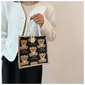 Detailed view of linen bear handbag featuring a wooden button closure and cotton rope handles