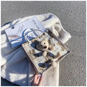 Close-up of cute 3D plush bear on minimalist canvas tote bag with woven handles