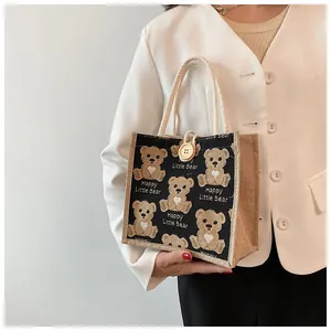 Detail of linen tote bag featuring cute bear patterns and braided rope handle