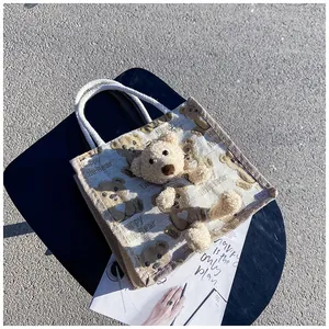 Detail of canvas lunch bag featuring 3D plush bear head and woven rope handle