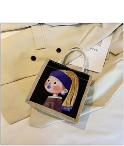 Detail van canvas tas met artistieke portretopdruk en crème geweven touwhandvatten