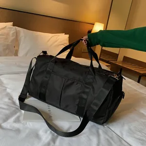 Large black nylon travel bag with waterproof compartments and detachable shoulder strap
