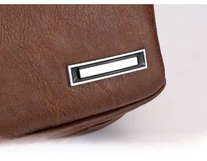 Détail de la texture en cuir PU marron et de la boucle en métal argenté sur le sac