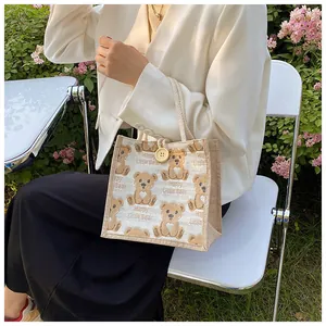 Detail of linen tote bag with cartoon bear pattern and natural wooden button closure
