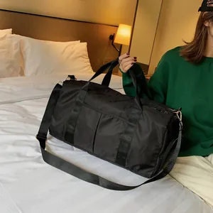 Detailed view of black waterproof nylon gym bag with double handles and adjustable shoulder strap