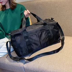 Detail view of black nylon fitness bag with durable gold hardware and adjustable strap