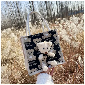 Close-up of cute cartoon bear print on canvas tote bag with 3D plush bear ornament