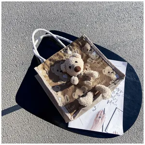 Detail of canvas lunch bag featuring 3D plush bear and Happy Little Bear print