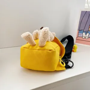 Dettaglio della borsa a tracolla in tela gialla con decori in peluche e tracolla regolabile