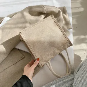 Minimalist jute tote bag with white woven rope handles in a natural khaki finish