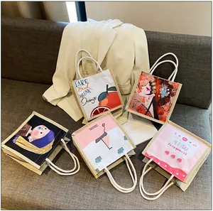 Set of five mini canvas tote bags with various artistic prints on a soft gray sofa