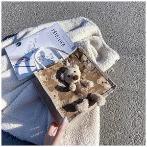 Detail of canvas mini tote bag featuring 3D plush bear and Happy Little Bear print