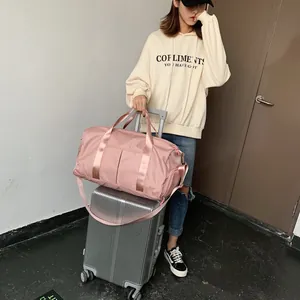 Pink waterproof travel bag detail with luggage sleeve and adjustable nylon shoulder strap