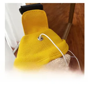 Dettaglio del foro per auricolari e dell'orsetto di peluche sulla borsa in tela gialla