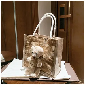 Close-up of canvas bear bag featuring 3D plush charm and Little Bear printing