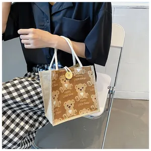 Detail of linen tote bag with cartoon bears and decorative wooden button closure