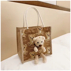 Detail of jute tote bag with 3D plush bear, cotton rope handle and printed text