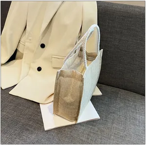 Detail view of woven linen tote bag with rope handle and zipper on a soft textured sofa
