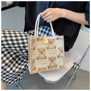 Detail of linen tote bag with cartoon bear prints and decorative button closure