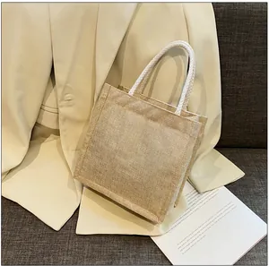 Detailed texture of natural woven jute tote bag with soft white cotton rope handles